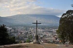 Město Antigua, kříž a sopka Agua v pozadí, Guatemala